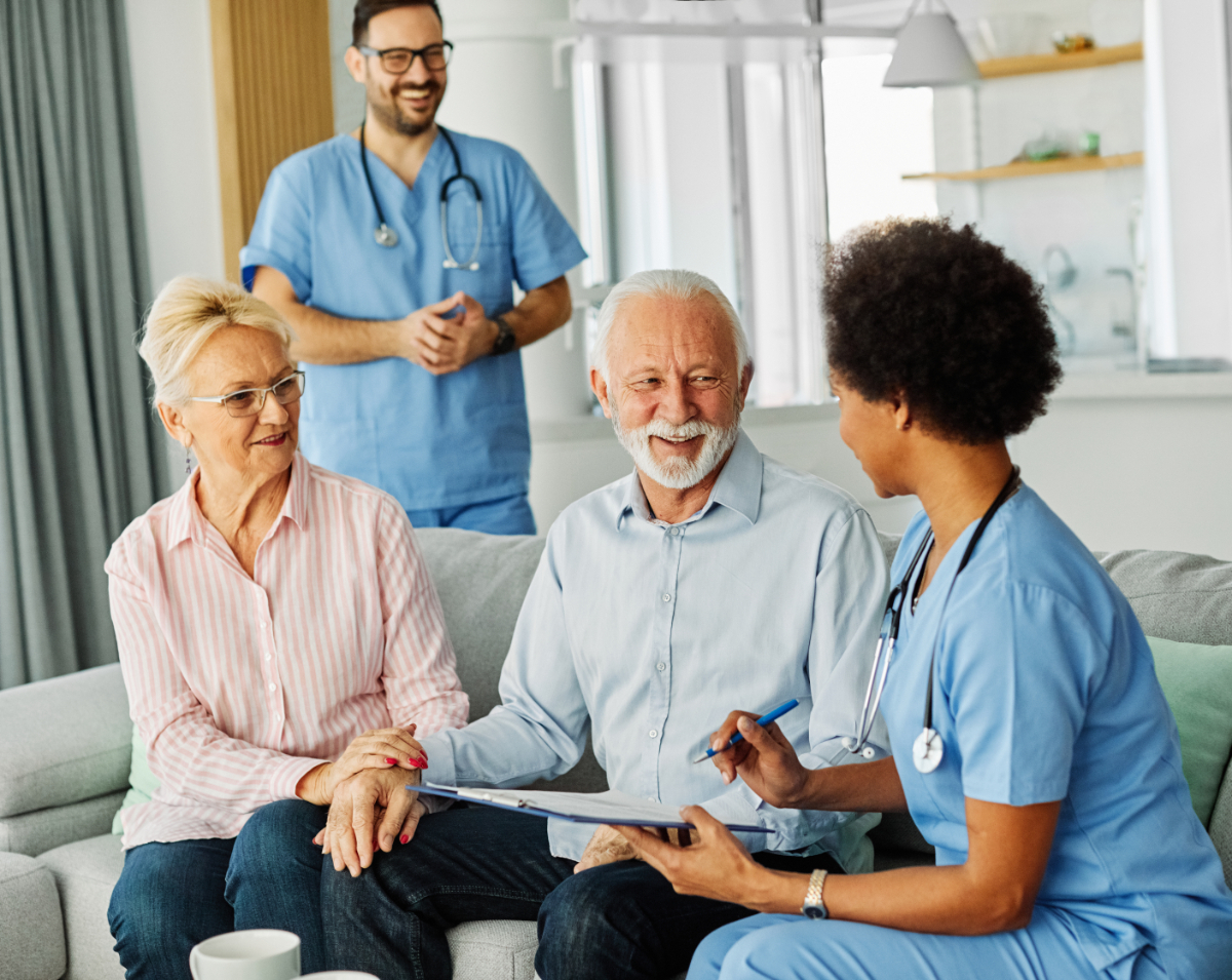 Doctor or nurse caregiver with senior couple at home or nursing home