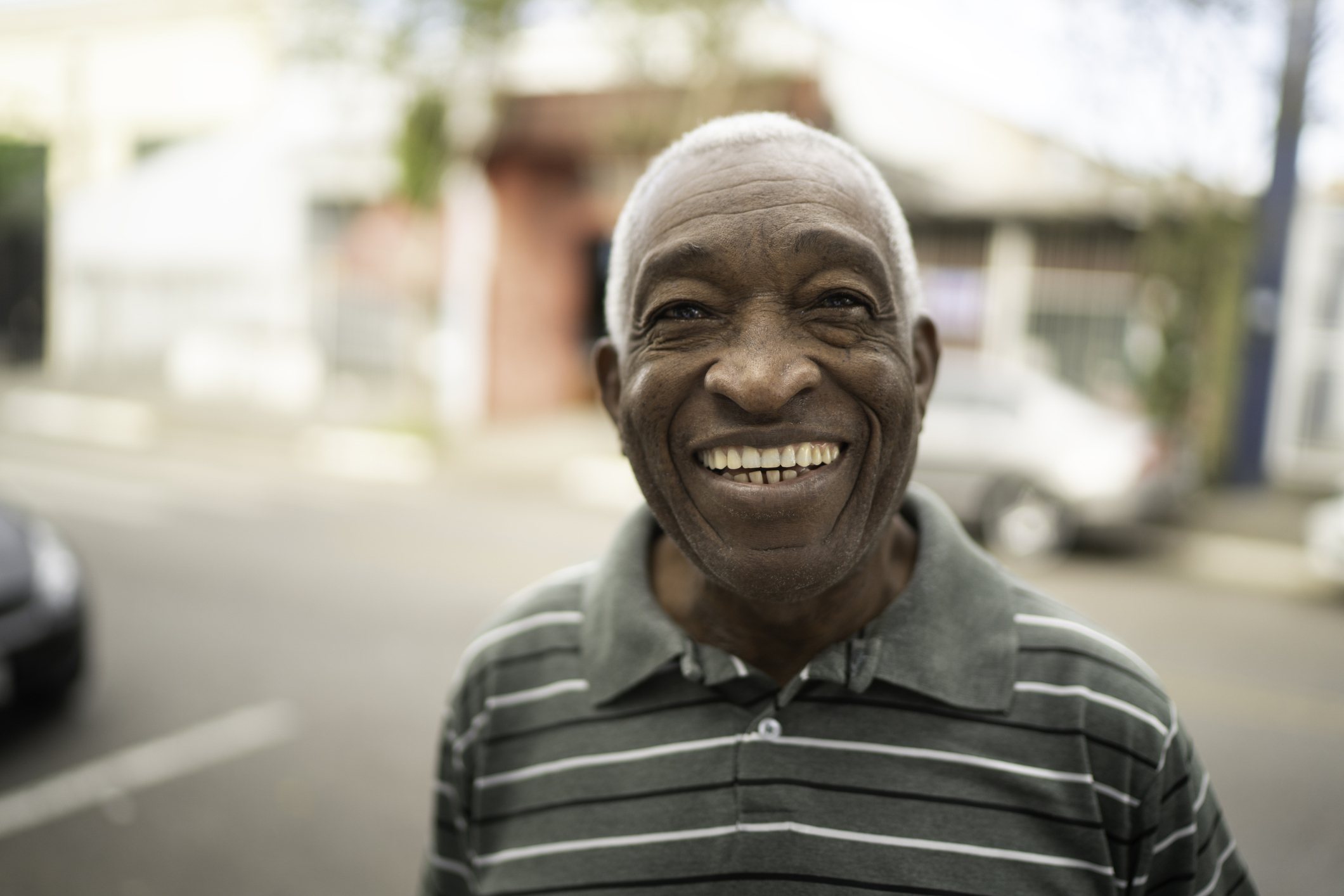 Portrait of smiling afro senior man looking at camera on the street